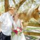 pink-floral-hacienda-wedding-newlyweds-with-horse