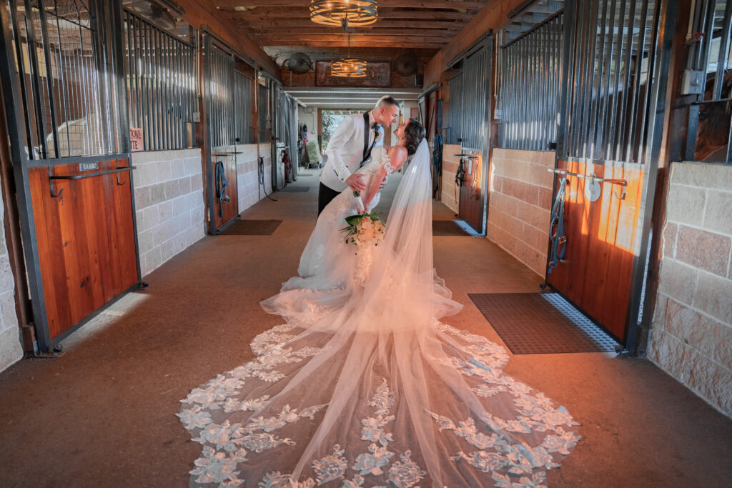 Bride-and-Groom-Kissing-In-A-Barn-Hallway