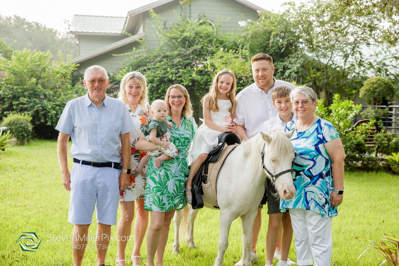 The whole family surrounding the little girl sitting on Bandit during the anniversary photoshoot